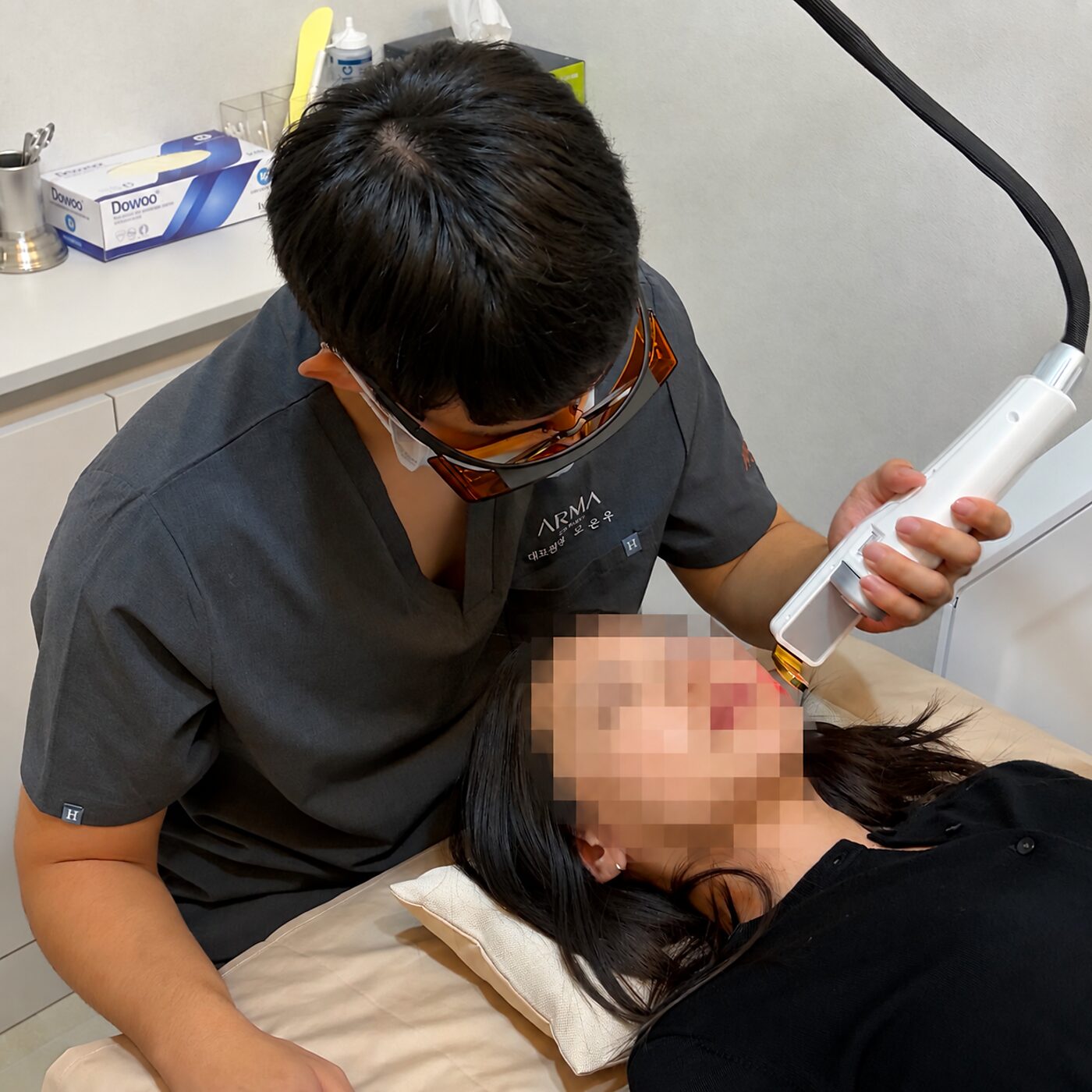 아르마의원 대표원장이 레이저 장비로 색소 부위에 레이저 토닝 시술을 진행하는 모습
